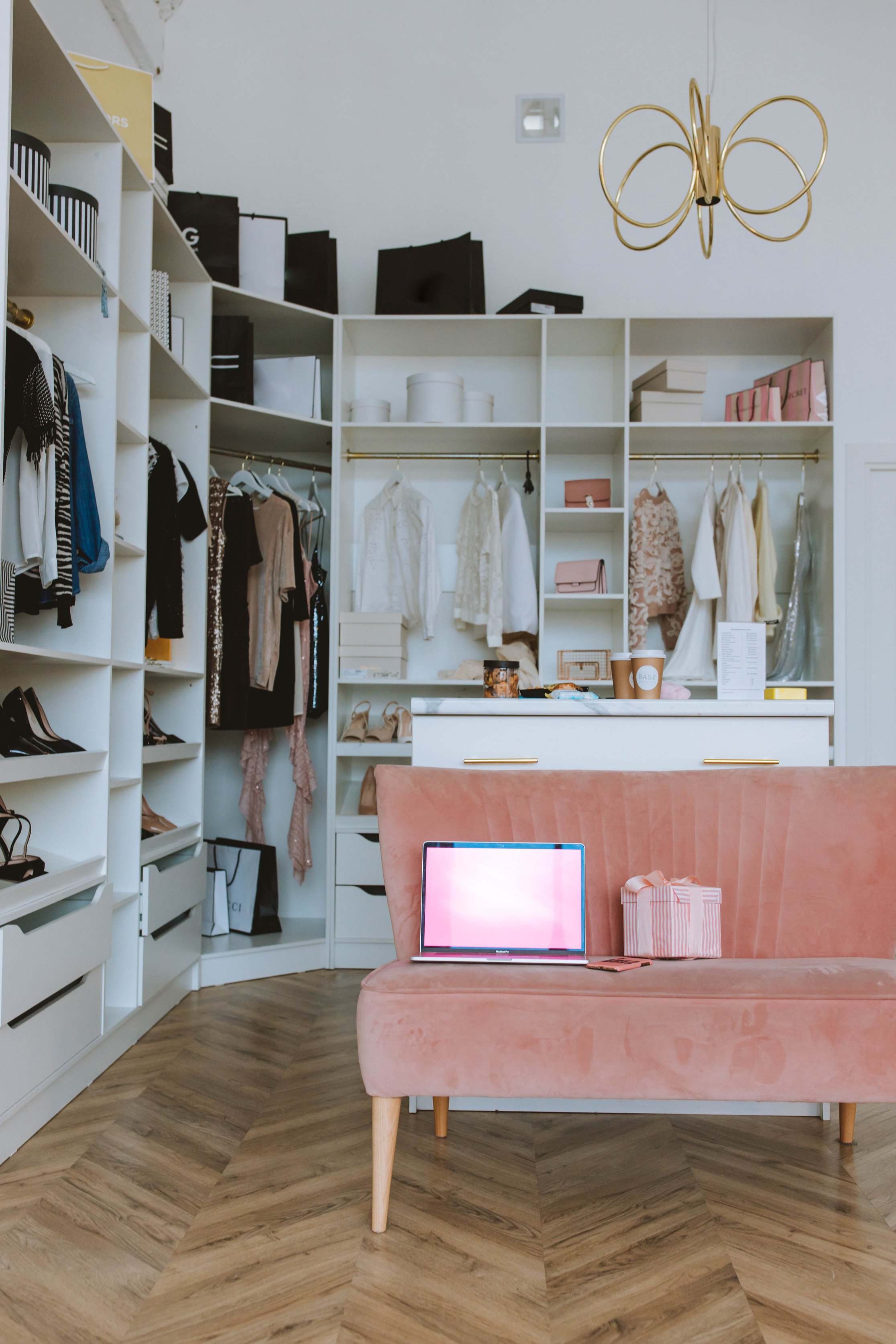 A Laptop on Pink Couch Inside A Walk-In Closet